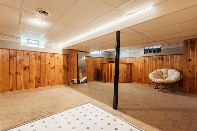 387 Brandon Rd, Irondequoit, NY 14622 - basement featuring a drop ceiling, carpet floors, wood walls, and tile patterned floors