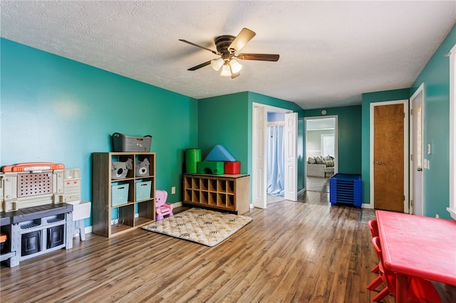 387 Brandon Rd, Irondequoit, NY 14622 - rec room with wood finished floors, a ceiling fan, and a textured ceiling