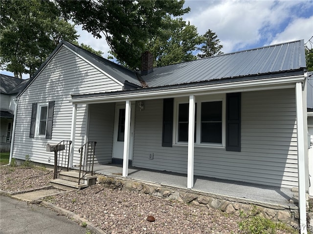 504 Allen Rd, Clay, NY 13212 - view of front facade featuring a porch, a metal roof, and a chimney