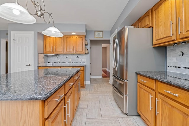 203 Torrey Pine Dr, Greece, NY 14612 - kitchen with freestanding refrigerator, dark stone countertops, brown cabinetry, and tasteful backsplash