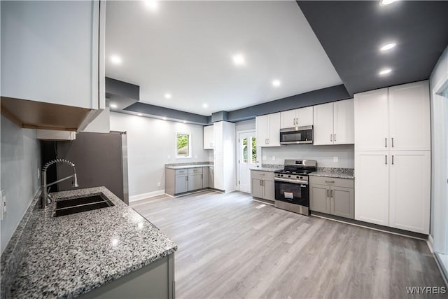 187 Lock St, Lockport-City, NY 14094 - kitchen featuring stainless steel appliances, light wood-style floors, light stone countertops, recessed lighting, and white cabinetry