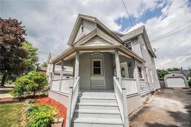 187 Lock St, Lockport-City, NY 14094 - view of front of house featuring a porch, an outbuilding, asphalt driveway, and a detached garage