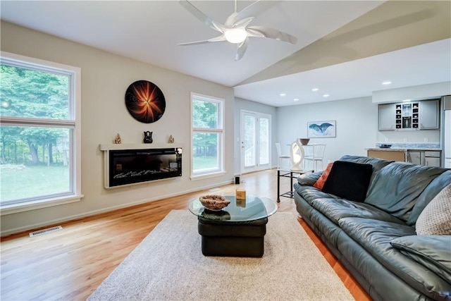 40 Little Glen Rd, Henrietta, NY 14534 - living room featuring light wood-style flooring, a glass covered fireplace, bar, a ceiling fan, and lofted ceiling