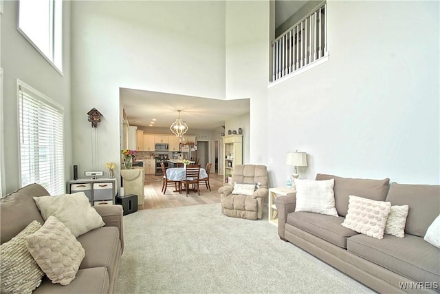 5472 Sycamore Ln, Hamburg, NY 14075 - living area featuring a high ceiling, a chandelier, and light wood-style flooring