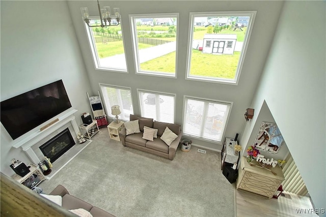 5472 Sycamore Ln, Hamburg, NY 14075 - carpeted living area featuring a towering ceiling and a glass covered fireplace
