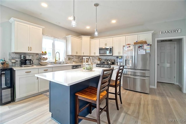 5472 Sycamore Ln, Hamburg, NY 14075 - kitchen with appliances with stainless steel finishes, backsplash, a breakfast bar, light wood finished floors, and recessed lighting