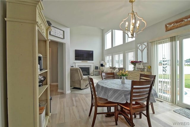 5472 Sycamore Ln, Hamburg, NY 14075 - dining room featuring a fireplace, light wood-style floors, and a chandelier