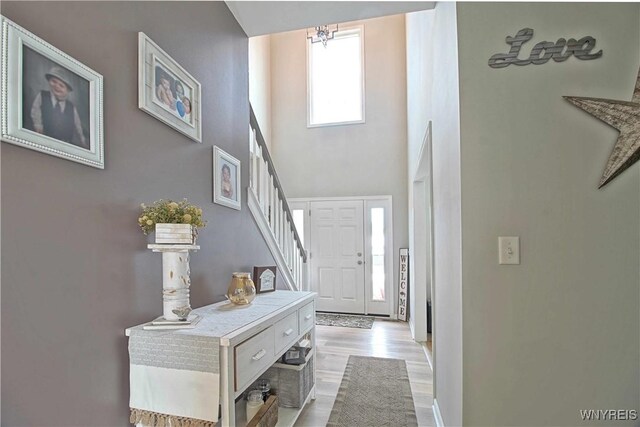 5472 Sycamore Ln, Hamburg, NY 14075 - foyer featuring a high ceiling, stairway, wood finished floors, and a chandelier