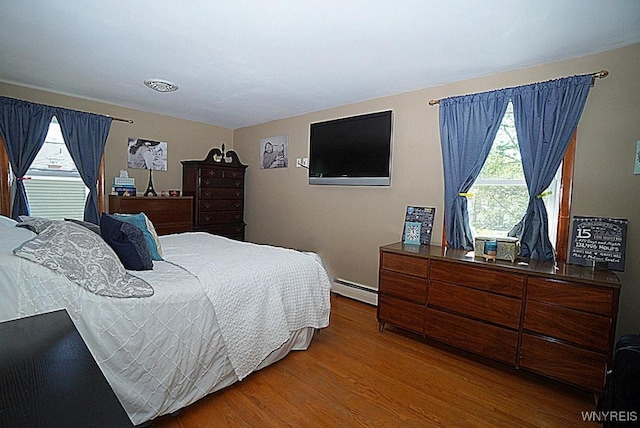 3042 Baseline Rd, Grand Island, NY 14072 - bedroom with a baseboard radiator, multiple windows, and wood finished floors