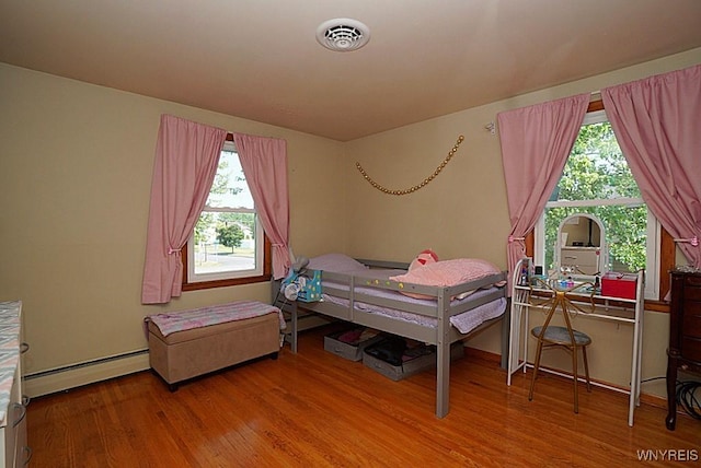 3042 Baseline Rd, Grand Island, NY 14072 - bedroom with baseboard heating, wood finished floors, and multiple windows