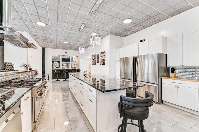 11059 Gold Seal Way, Urbana, NY 14840 - kitchen featuring appliances with stainless steel finishes, a kitchen island, white cabinets, tasteful backsplash, and recessed lighting