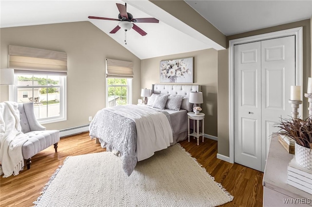 79 Hemlock Dr, West Seneca, NY 14224 - bedroom featuring wood finished floors, a closet, lofted ceiling, a ceiling fan, and a baseboard heating unit