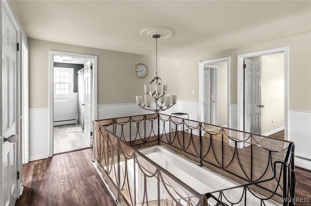 79 Hemlock Dr, West Seneca, NY 14224 - hallway featuring an upstairs landing, a chandelier, dark wood-style floors, and baseboard heating