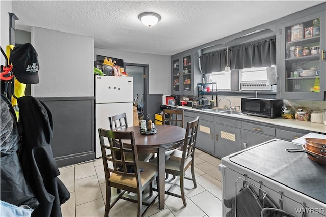 540 17th St, Niagara Falls, NY 14301 - kitchen featuring black microwave, gray cabinetry, freestanding refrigerator, range, and a textured ceiling