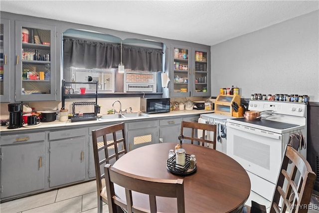 540 17th St, Niagara Falls, NY 14301 - kitchen with white electric range, gray cabinetry, black microwave, and glass insert cabinets