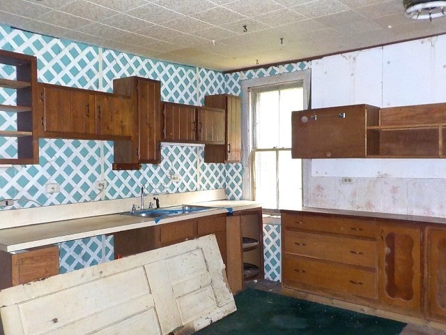 1140 N Main St, Arcadia, NY 14513 - kitchen featuring open shelves, wallpapered walls, brown cabinets, and light countertops