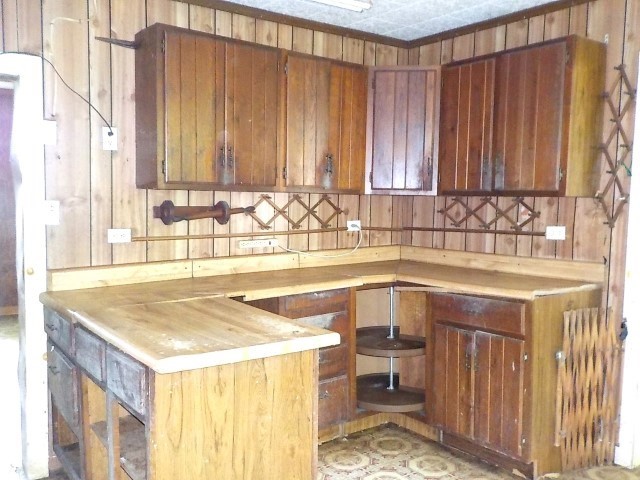 1140 N Main St, Arcadia, NY 14513 - kitchen featuring wooden walls and brown cabinetry