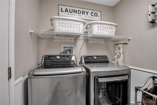 9210 Via Cimato Dr, Clarence, NY 14032 - washroom featuring independent washer and dryer, a wainscoted wall, and a decorative wall