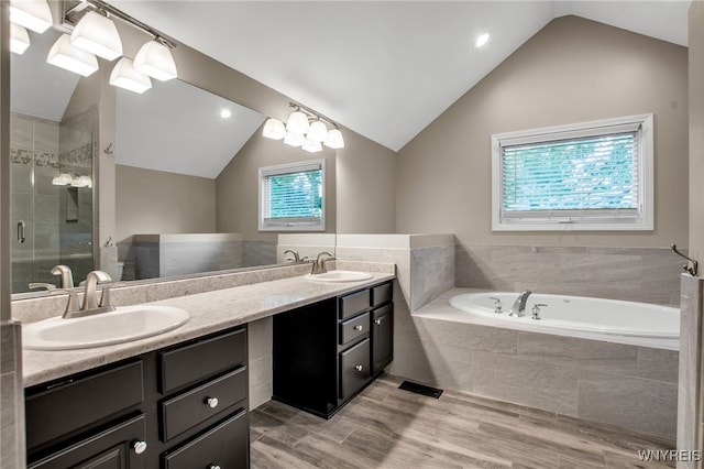 9210 Via Cimato Dr, Clarence, NY 14032 - bathroom with double vanity, a garden tub, lofted ceiling, a stall shower, and healthy amount of natural light