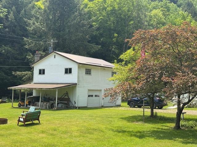 3627 Irish Ave Unit B, Willing, NY 14895 - view of home's exterior with a garage, a chimney, a yard, and a view of trees