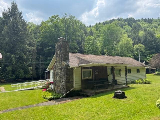 3627 Irish Ave Unit B, Willing, NY 14895 - view of front of property with a front lawn, a view of trees, a chimney, and a porch