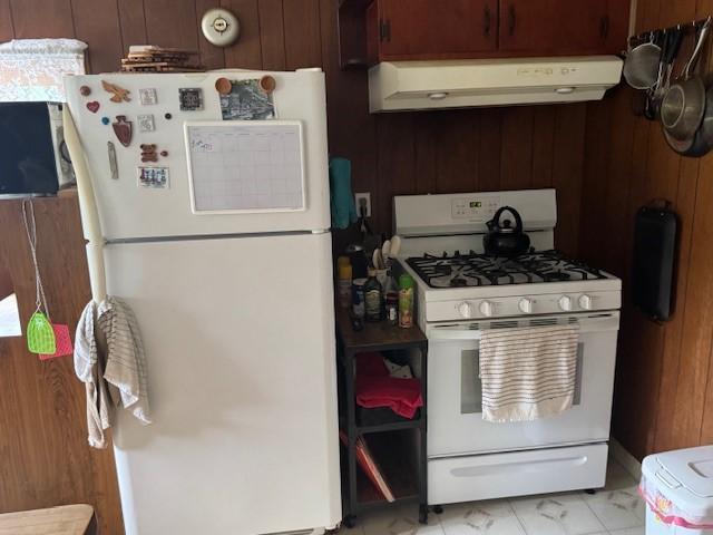 3627 Irish Ave Unit B, Willing, NY 14895 - kitchen featuring white appliances, custom exhaust hood, light marble finish flooring, and wood walls