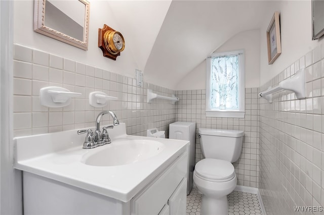 87 Pasadena Pl, Amherst, NY 14221 - bathroom featuring tile walls, tile patterned floors, vanity, a wainscoted wall, and vaulted ceiling