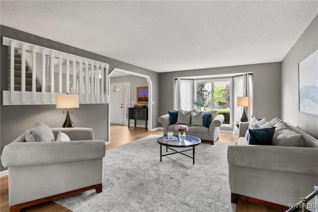 13 Thames Ct, Amherst, NY 14221 - living room featuring a textured ceiling, arched walkways, and wood finished floors
