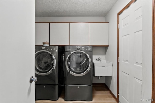 13 Thames Ct, Amherst, NY 14221 - washroom with cabinet space, washing machine and clothes dryer, a textured ceiling, and light wood-type flooring
