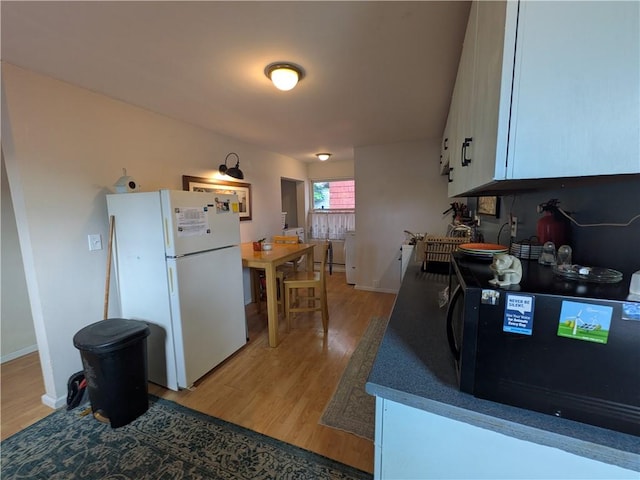 21 Charlotte Ave, Bradford City, PA 16701 - kitchen featuring freestanding refrigerator, black microwave, light wood-style flooring, and white cabinetry