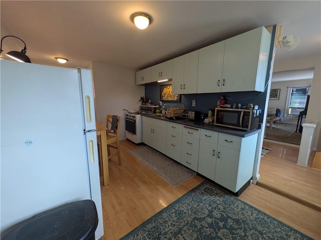 21 Charlotte Ave, Bradford City, PA 16701 - kitchen with white appliances, dark countertops, light wood finished floors, and white cabinets