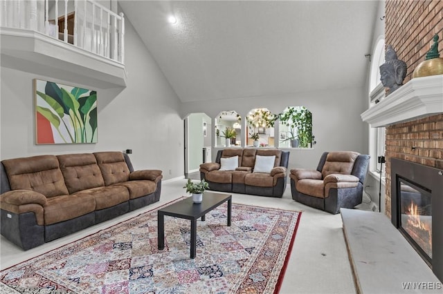 5103 Eastbrooke Pl, Clarence, NY 14221 - living area featuring high vaulted ceiling, a fireplace, arched walkways, and carpet floors