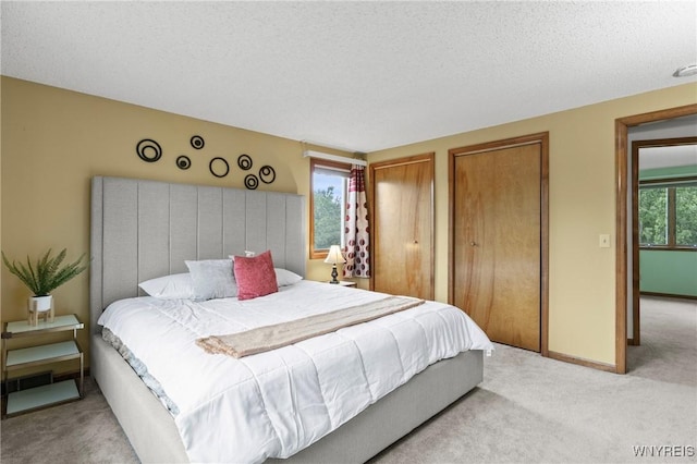 5103 Eastbrooke Pl, Clarence, NY 14221 - bedroom with light colored carpet, two closets, and a textured ceiling