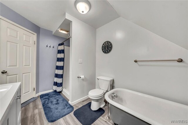 295 Continental Dr, Lockport City, NY 14094 - bathroom with wood finished floors, a freestanding tub, vanity, a shower with shower curtain, and lofted ceiling