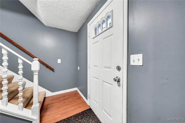 295 Continental Dr, Lockport City, NY 14094 - entryway featuring stairs, a textured ceiling, and wood finished floors