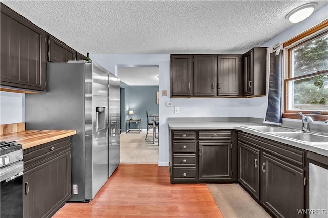 295 Continental Dr, Lockport City, NY 14094 - kitchen featuring a textured ceiling, appliances with stainless steel finishes, light wood-type flooring, and dark brown cabinets