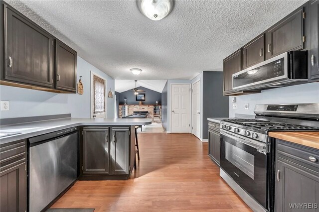 295 Continental Dr, Lockport City, NY 14094 - kitchen with stainless steel appliances, light wood-type flooring, a peninsula, and a textured ceiling