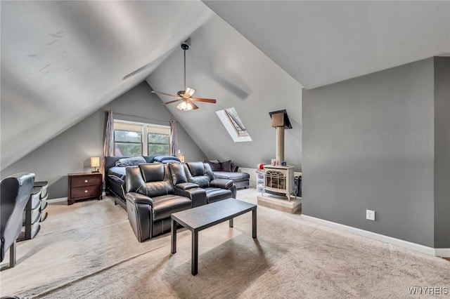 295 Continental Dr, Lockport City, NY 14094 - carpeted living room featuring a wood stove, a skylight, a ceiling fan, and lofted ceiling
