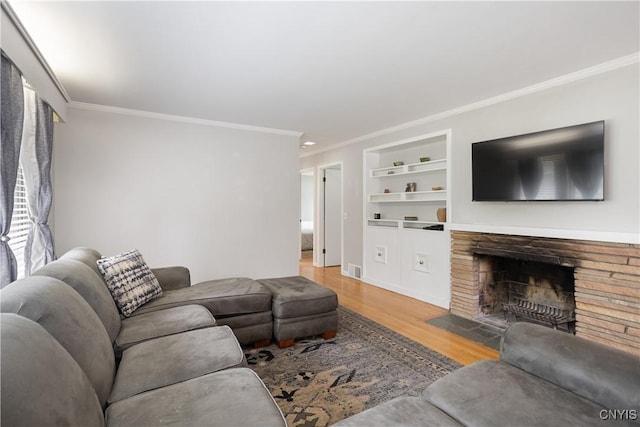 129 Butternut Dr, Dewitt, NY 13214 - living area with crown molding, built in shelves, wood finished floors, and a fireplace with flush hearth