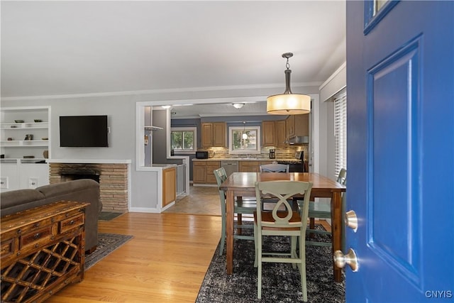 129 Butternut Dr, Dewitt, NY 13214 - dining room featuring crown molding, light wood-type flooring, and a fireplace