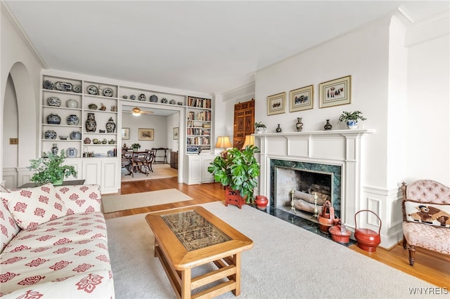 33 Gates Cir Unit 6B, Buffalo, NY 14222 - living room with light wood finished floors, a high end fireplace, crown molding, arched walkways, and built in shelves