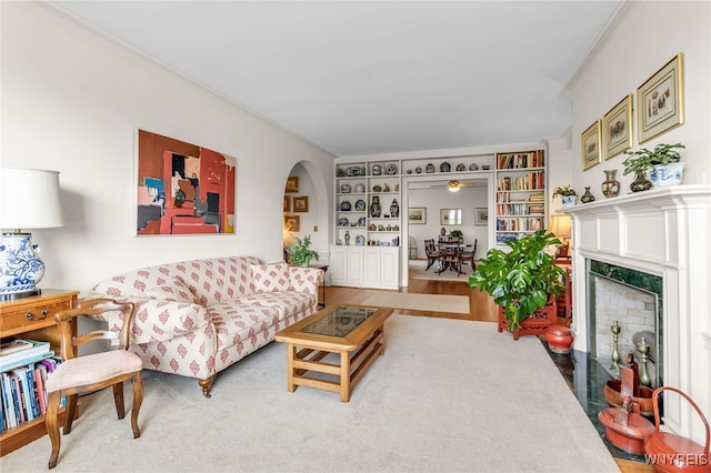 33 Gates Cir Unit 6B, Buffalo, NY 14222 - living room with arched walkways, built in shelves, a fireplace, ornamental molding, and ceiling fan