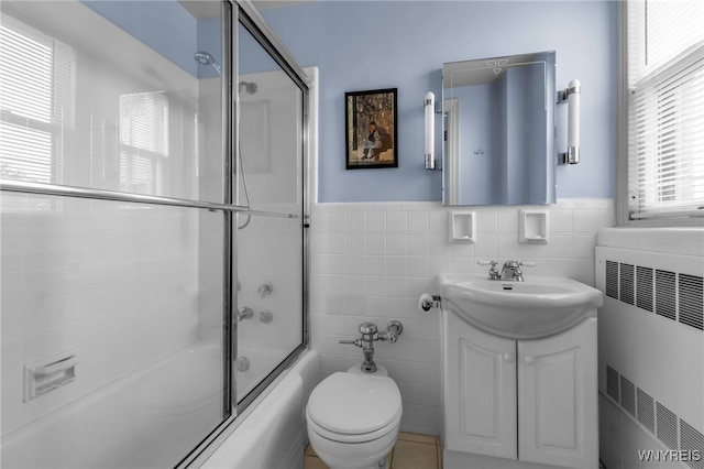 33 Gates Cir Unit 6B, Buffalo, NY 14222 - full bathroom with radiator heating unit, tile walls, vanity, combined bath / shower with glass door, and wainscoting