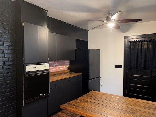 92 Abbott St, Rochester, NY 14606 - kitchen featuring oven, freestanding refrigerator, a ceiling fan, decorative backsplash, and dark cabinets