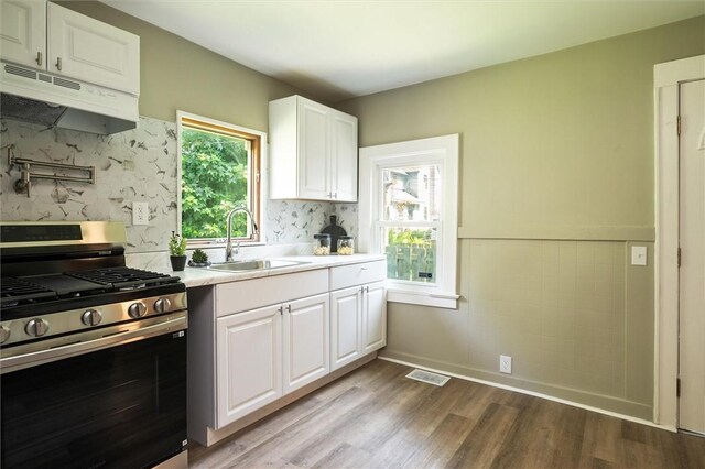69 Diem St, Rochester, NY 14620 - kitchen featuring gas stove, under cabinet range hood, dark wood-style floors, and light countertops