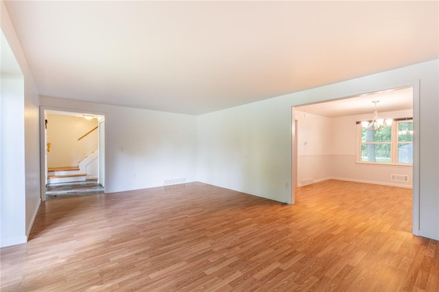 10 Chesfield Lookout, Perinton, NY 14450 - spare room featuring a chandelier, light wood-style flooring, and stairway
