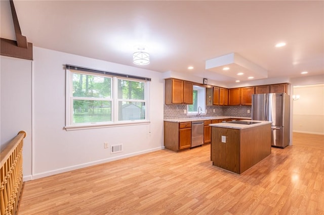 10 Chesfield Lookout, Perinton, NY 14450 - kitchen featuring appliances with stainless steel finishes, light wood-type flooring, brown cabinets, backsplash, and light countertops