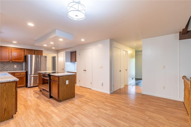10 Chesfield Lookout, Perinton, NY 14450 - kitchen featuring electric range, freestanding refrigerator, light wood-style flooring, brown cabinets, and backsplash