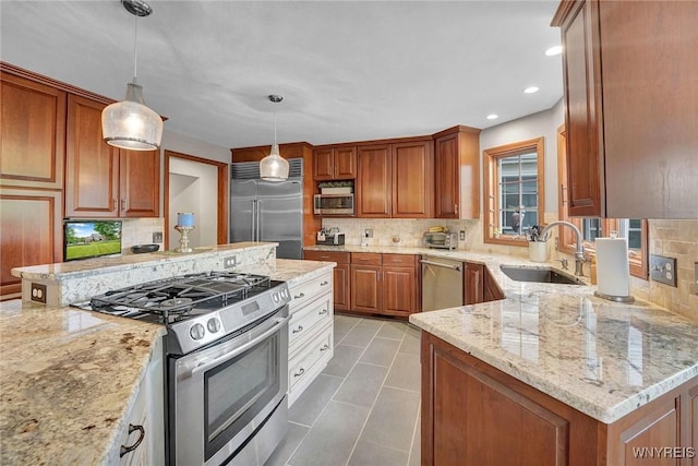135 Fox Meadow Ln, Orchard Park, NY 14127 - kitchen featuring stainless steel appliances, backsplash, light stone countertops, decorative light fixtures, and brown cabinetry