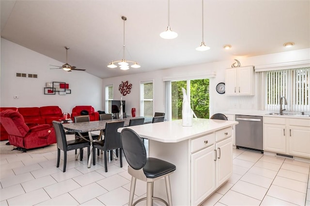 8 Brongo Ln, Gates, NY 14559 - kitchen featuring dishwasher, lofted ceiling, light countertops, white cabinetry, and a center island